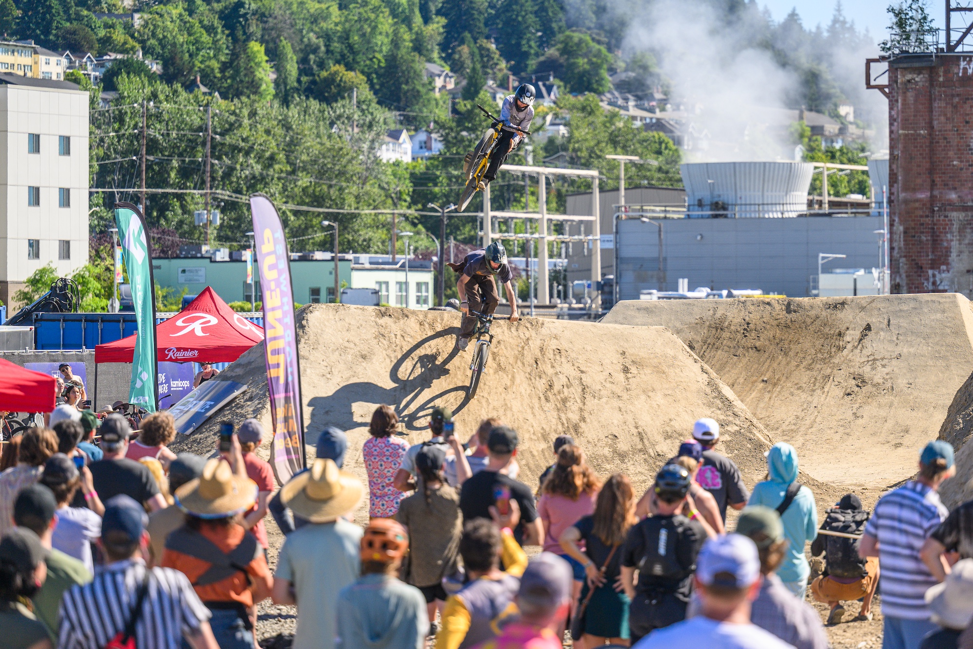 A rider catches air on the trail with a cheering squad on the sidelines