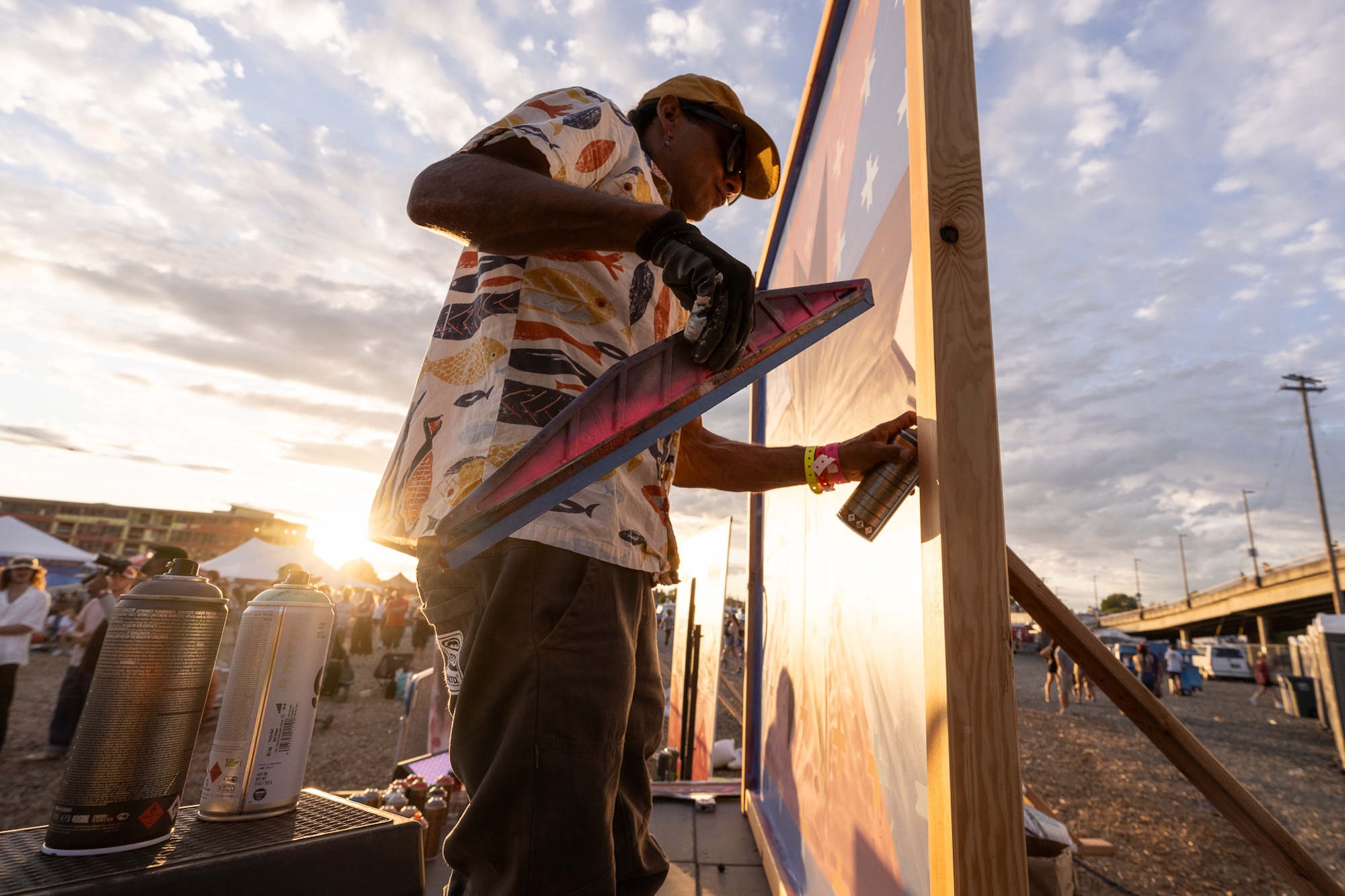 An artist paints a mural at sunset at the NW Tune-Up main stage.